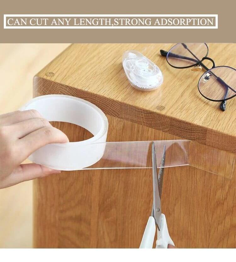 Hand using Reusable Nano Adhesive Tape on a wooden surface, showcasing strong adhesion and versatility.