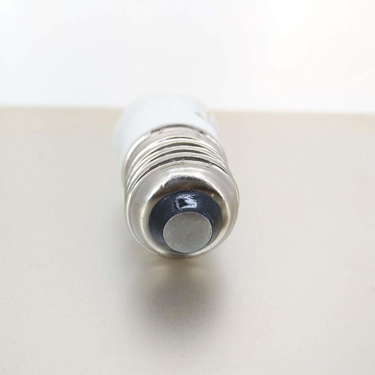 Close-up of E27 Male light bulb adapter for converting B22 bayonet bulbs.