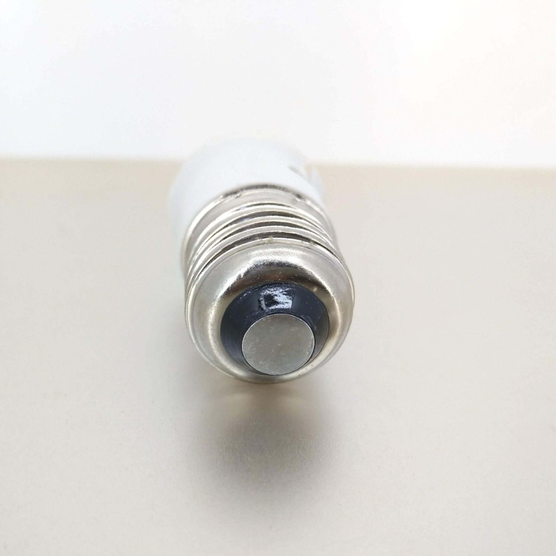 Close-up of E27 Male light bulb adapter for converting B22 bayonet bulbs.