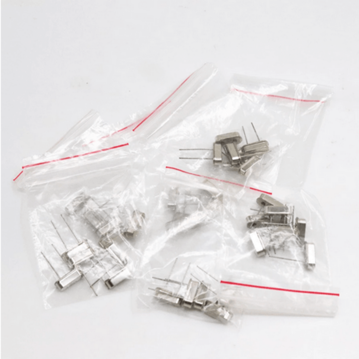Crystal oscillator components in sealed bags, part of a 35-piece electronic kit for DIY projects.