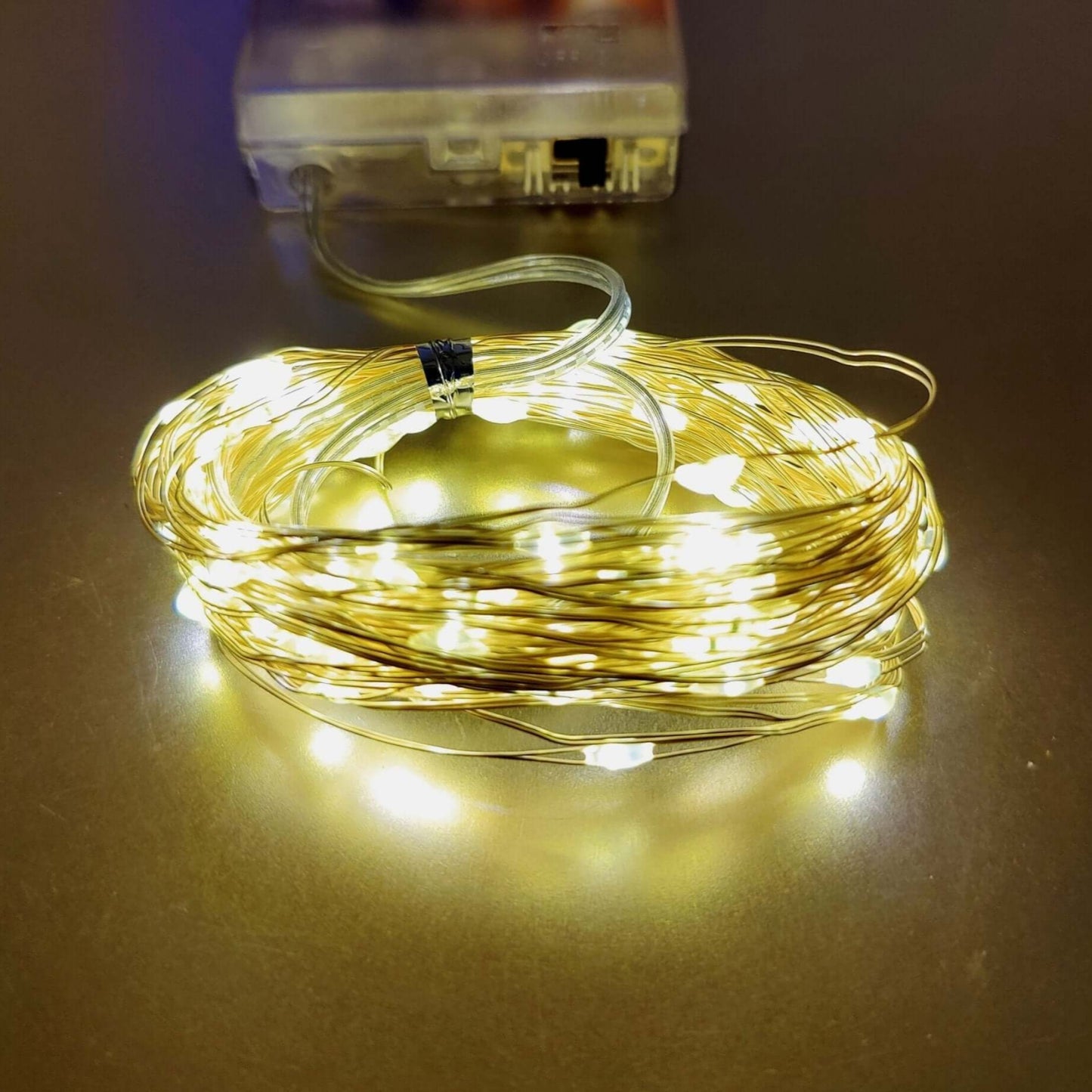 Warm white LED string lights on copper wire, battery-powered for festive decoration indoors and outdoors.
