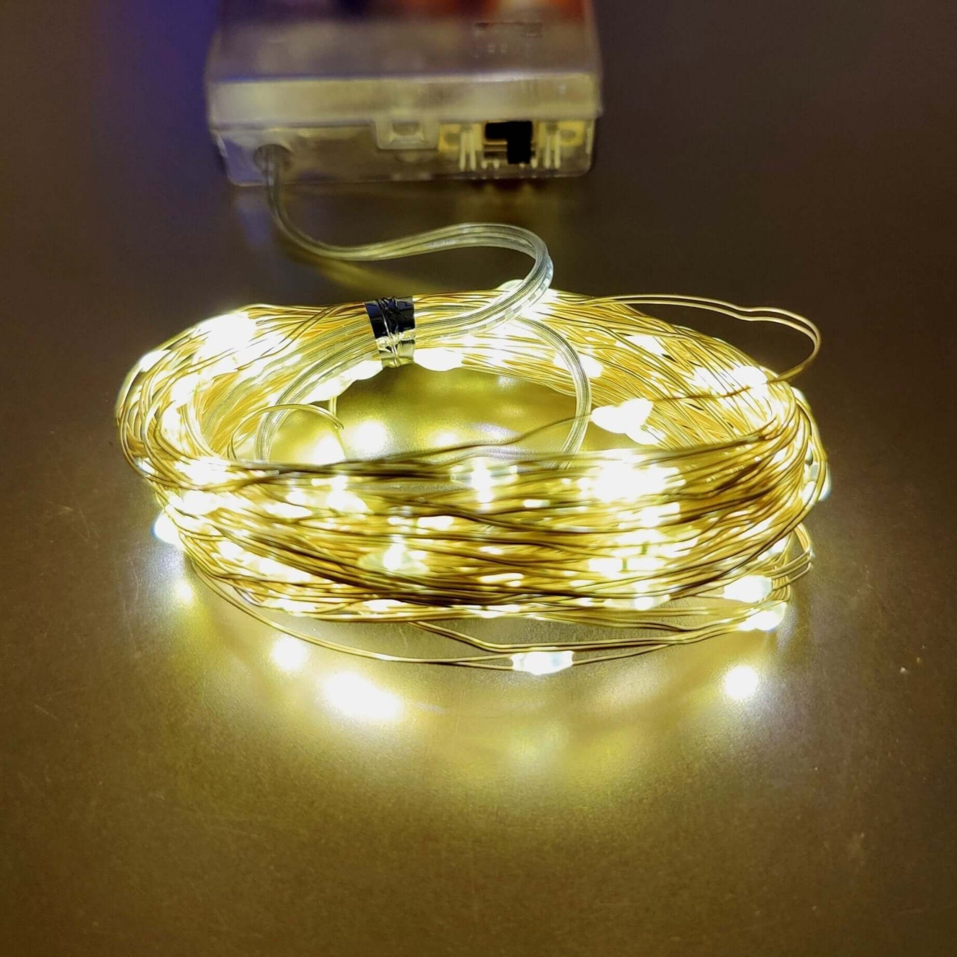 Warm white LED string lights on copper wire, battery-powered for festive decoration indoors and outdoors.