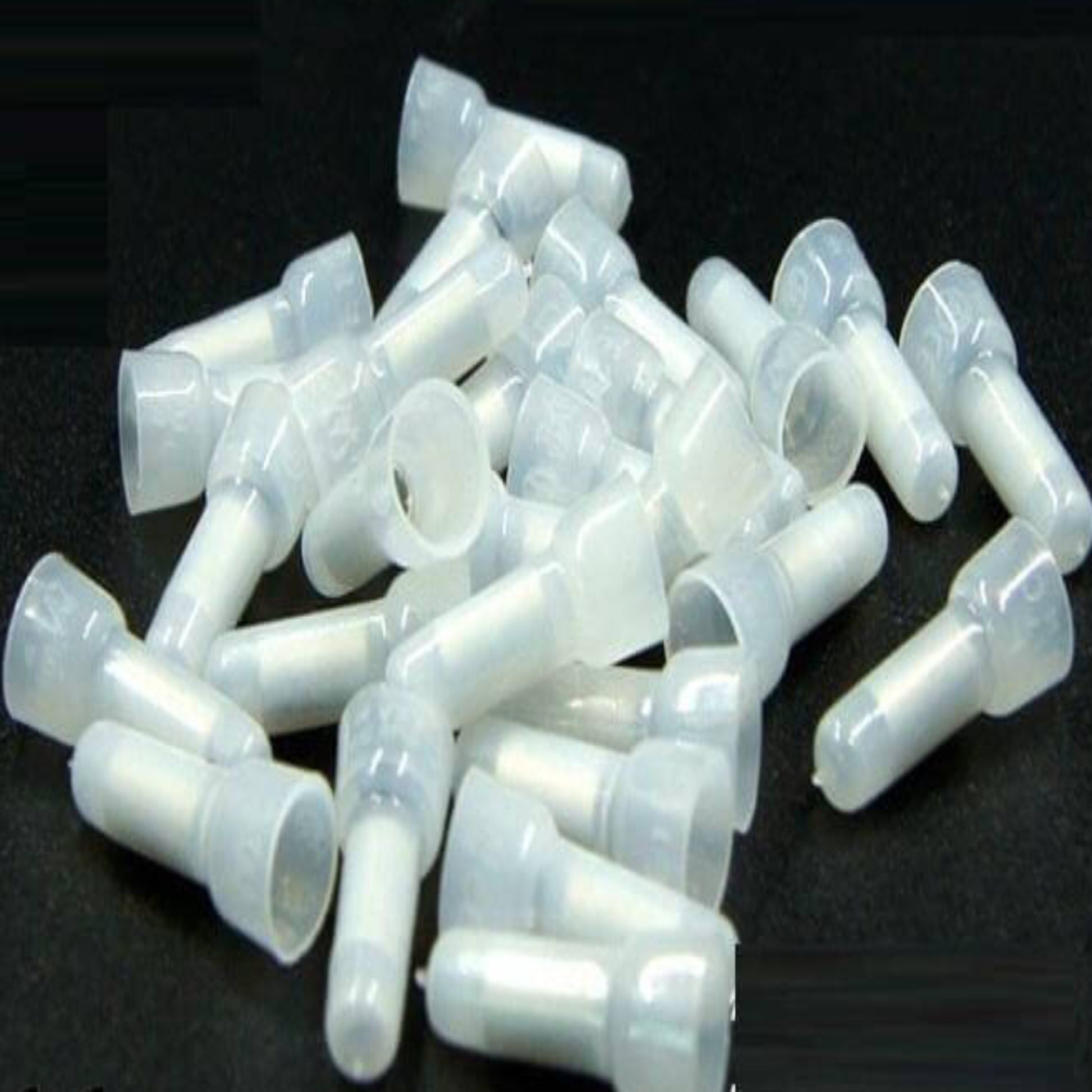 A close-up view of multiple CE-2X closed-end wire connectors, showing the white PP material and internal aluminum tube.