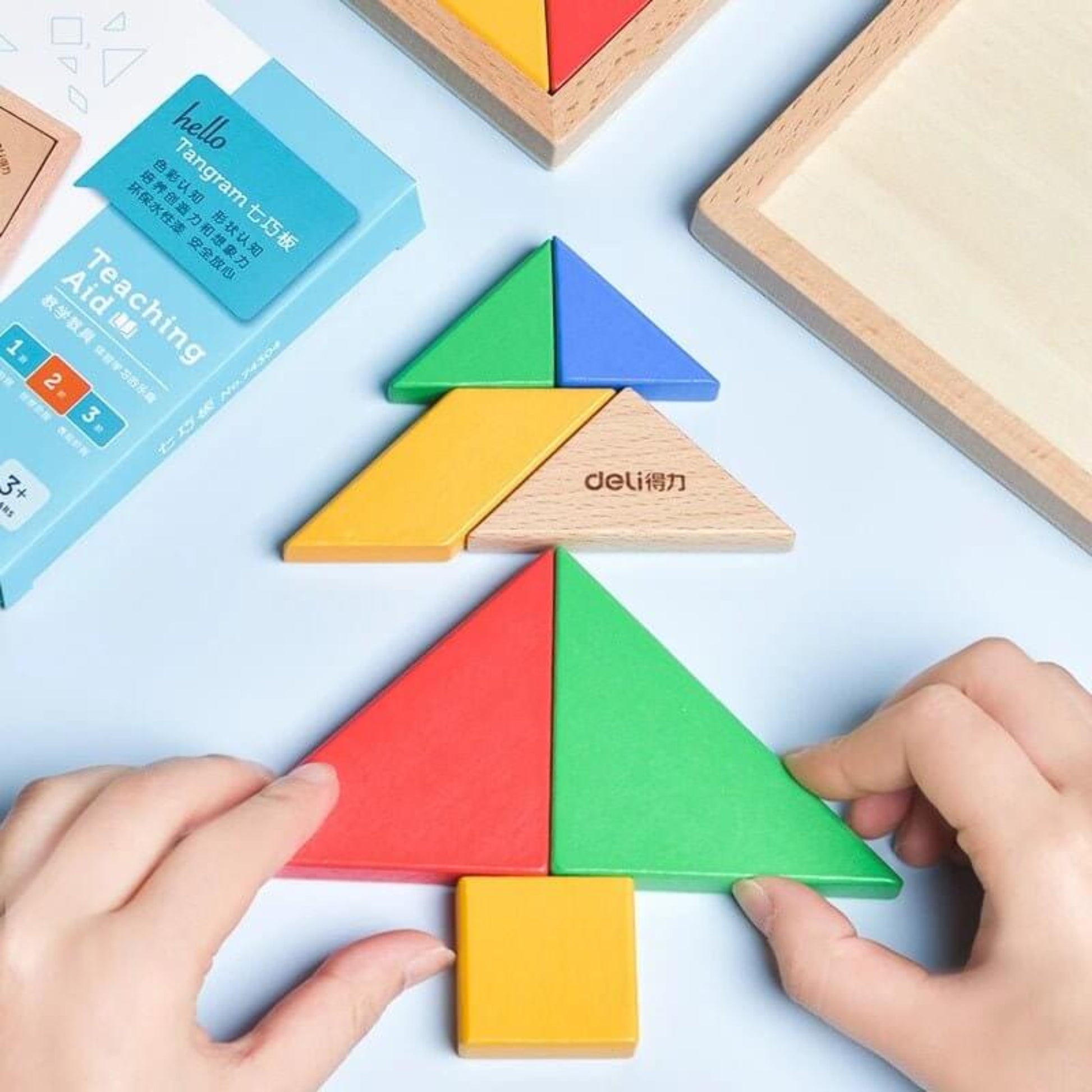 Child assembling a tree shape using a wooden tangram puzzle