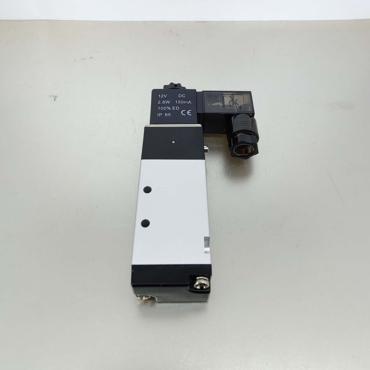 Close-up of the black solenoid coil displaying specifications: 12V DC, 2.8W, 150mA, 100 percent ED, and CE certification.
