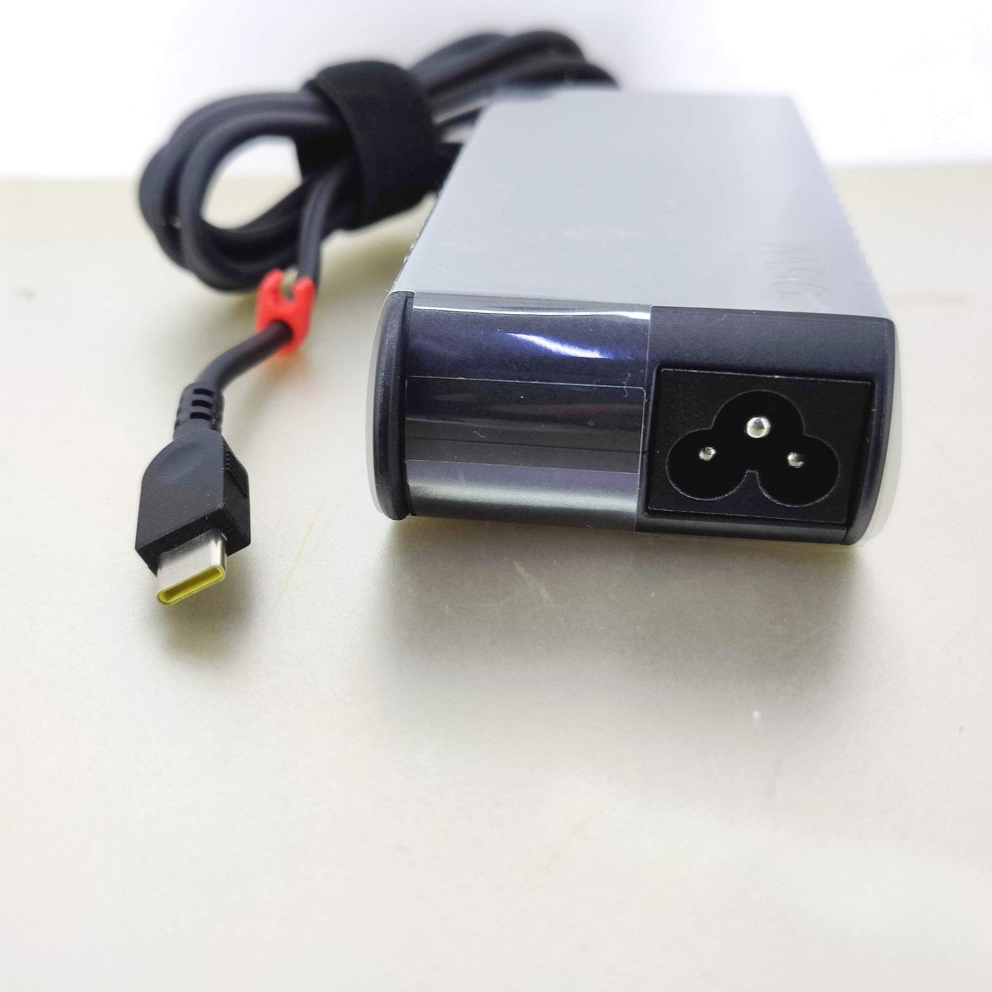 Lenovo 95W USB-C laptop charger showing its input power port and USB-C output connector.