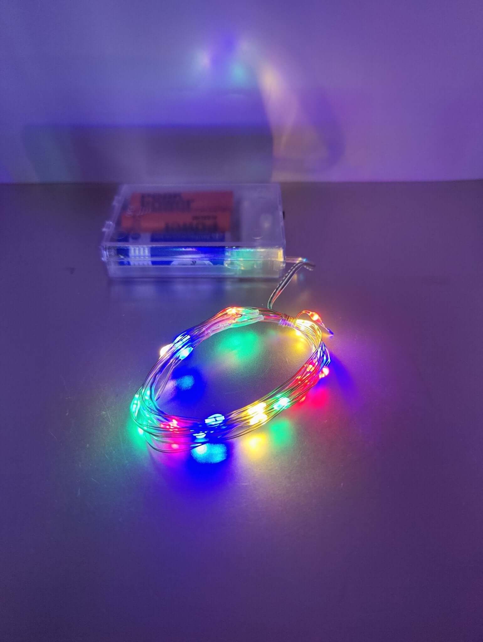 Multicolor LED fairy lights on silver wire, battery-operated for festive and cozy décor.