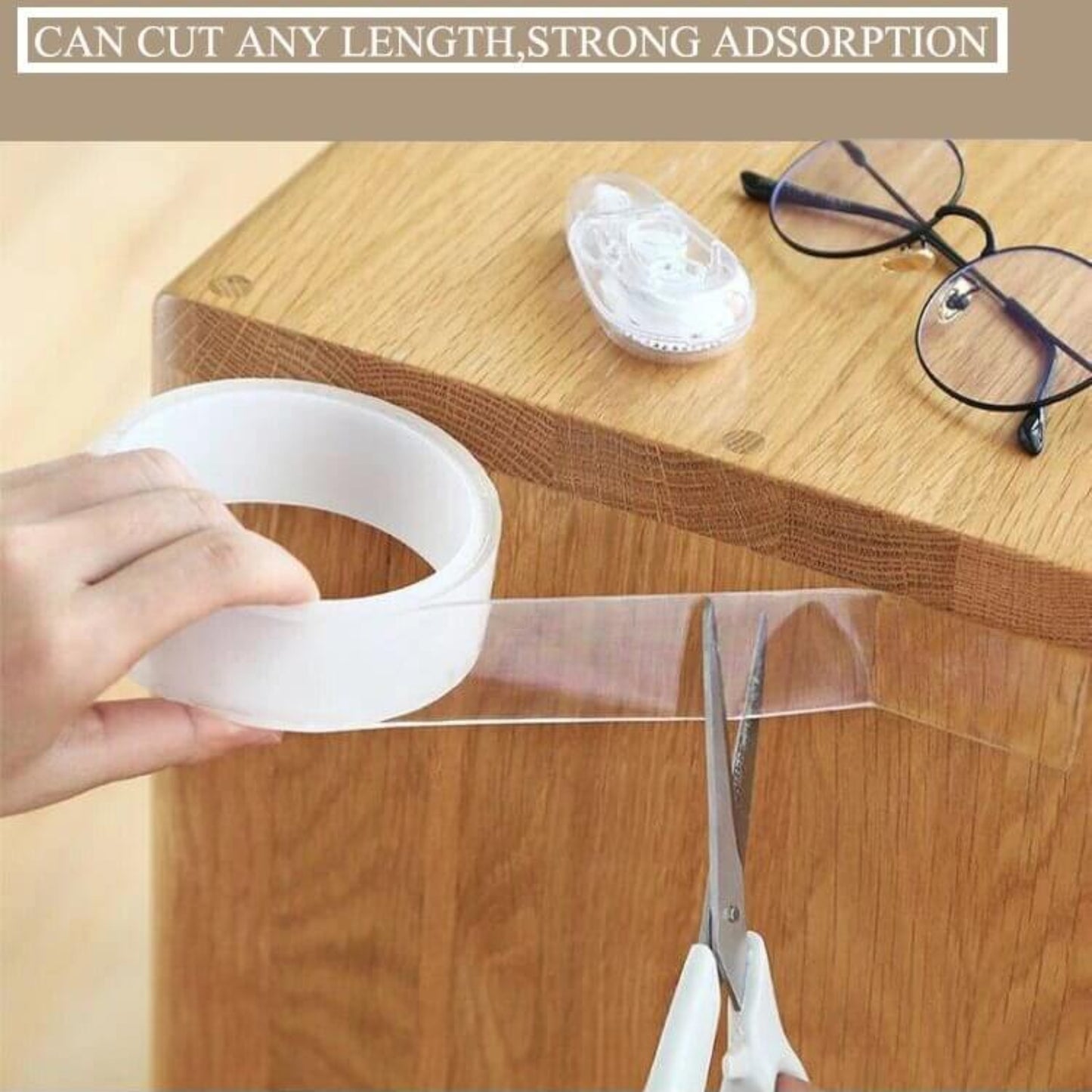 Hand using Reusable Nano Adhesive Tape on a wooden surface, showcasing strong adhesion and versatility.