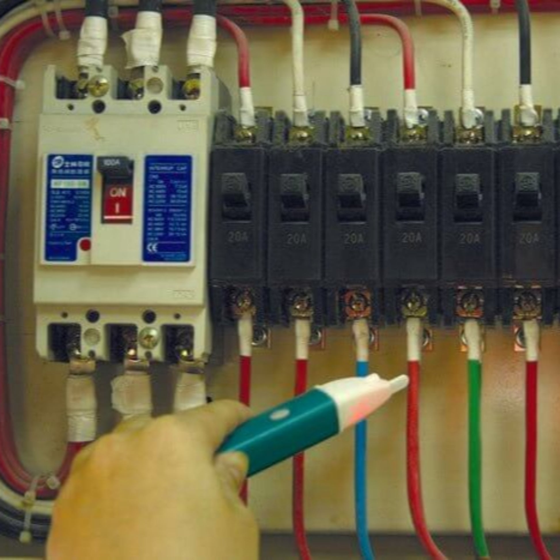 Hand using Pro'sKit NT-306 Voltage Detector Pen near electrical circuit breakers and wires.