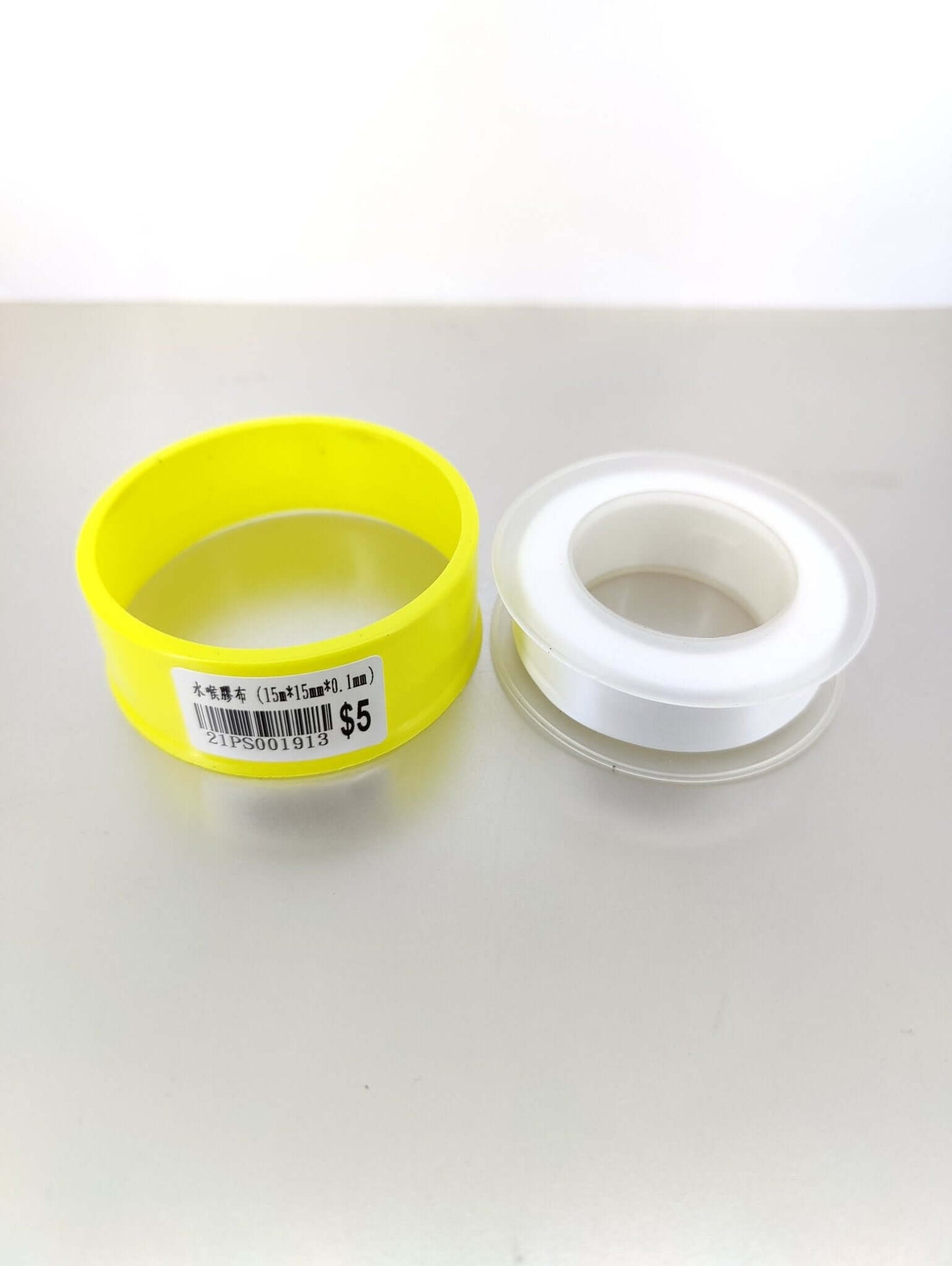 PTFE thread seal tape rolls, one yellow and one white, ideal for plumbing and gas pipe sealing.