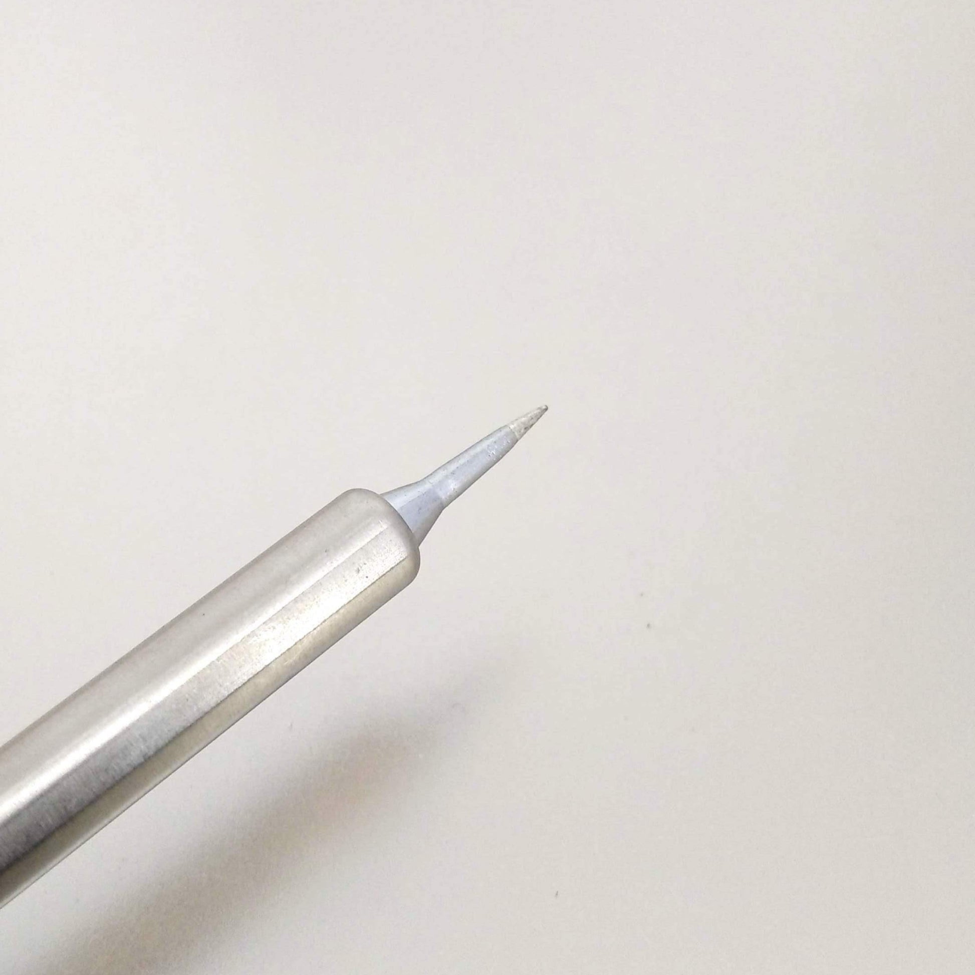 Close-up of a precision tip of a silver soldering iron, highlighting the fine point for detailed soldering tasks.