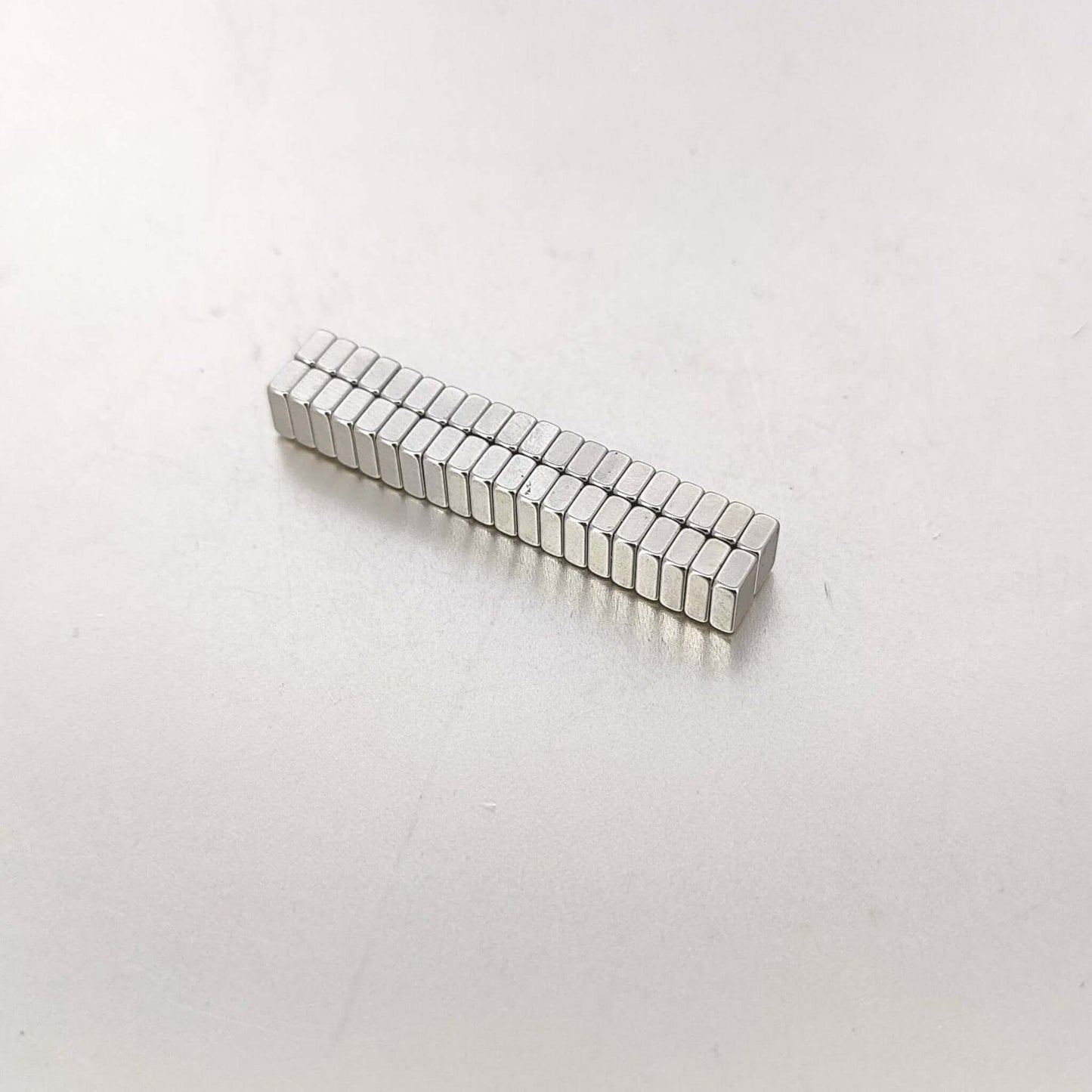Strong mini magnets 6x4x2mm arranged in a neat row, ideal for crafts and organization.